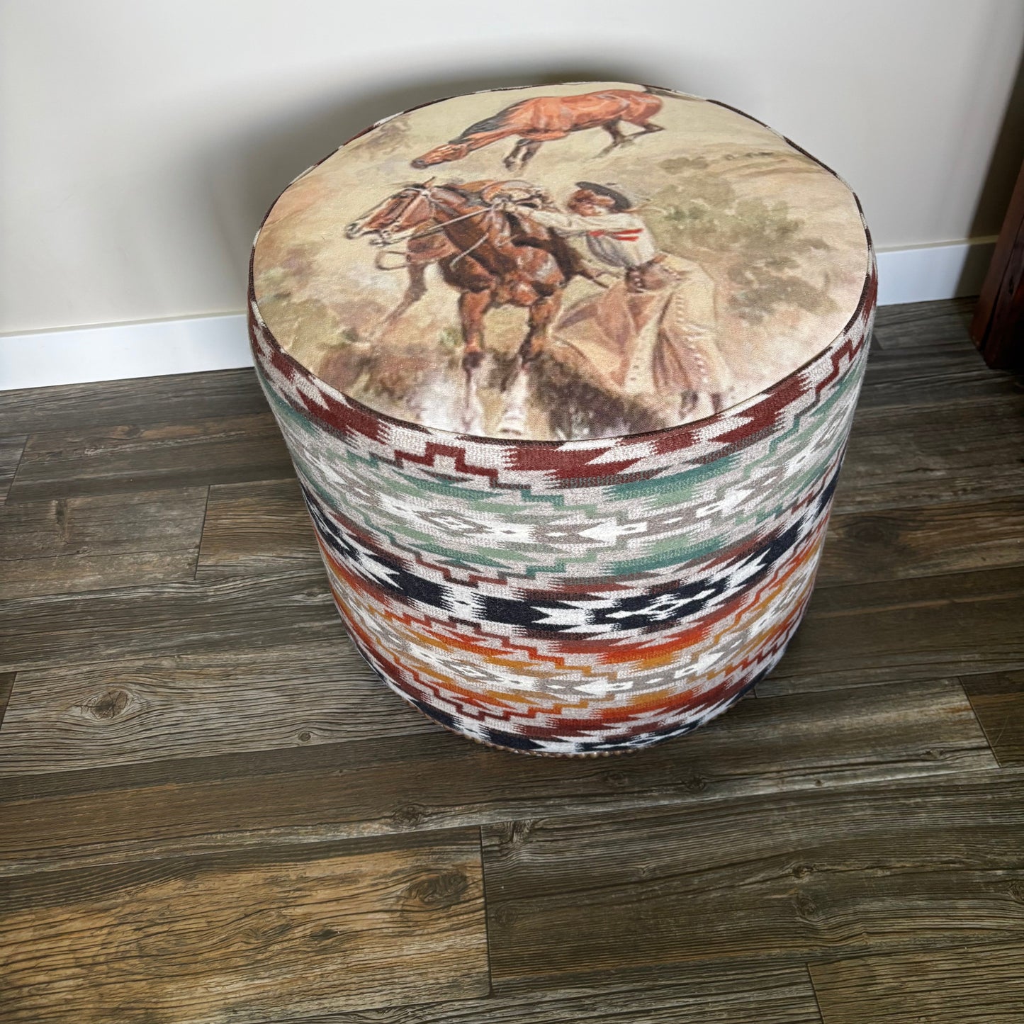 Handmade Alberta ottoman with Pendleton Mesilla fabric and Charlie Russell cowboy print (indoor photo, angled view)