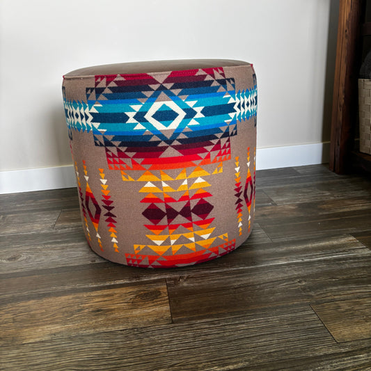 Handmade ottoman in indoor setting with Pendleton Pilot Rock pattern and leather top on wood flooring.
