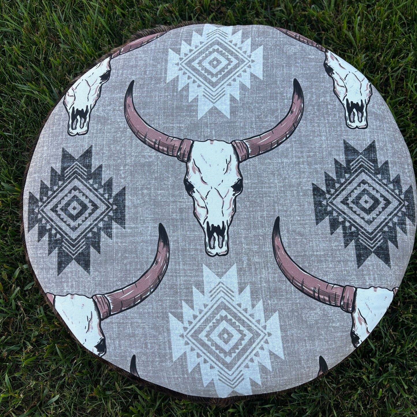 Outdoor top view of cow skull print ottoman on grass
