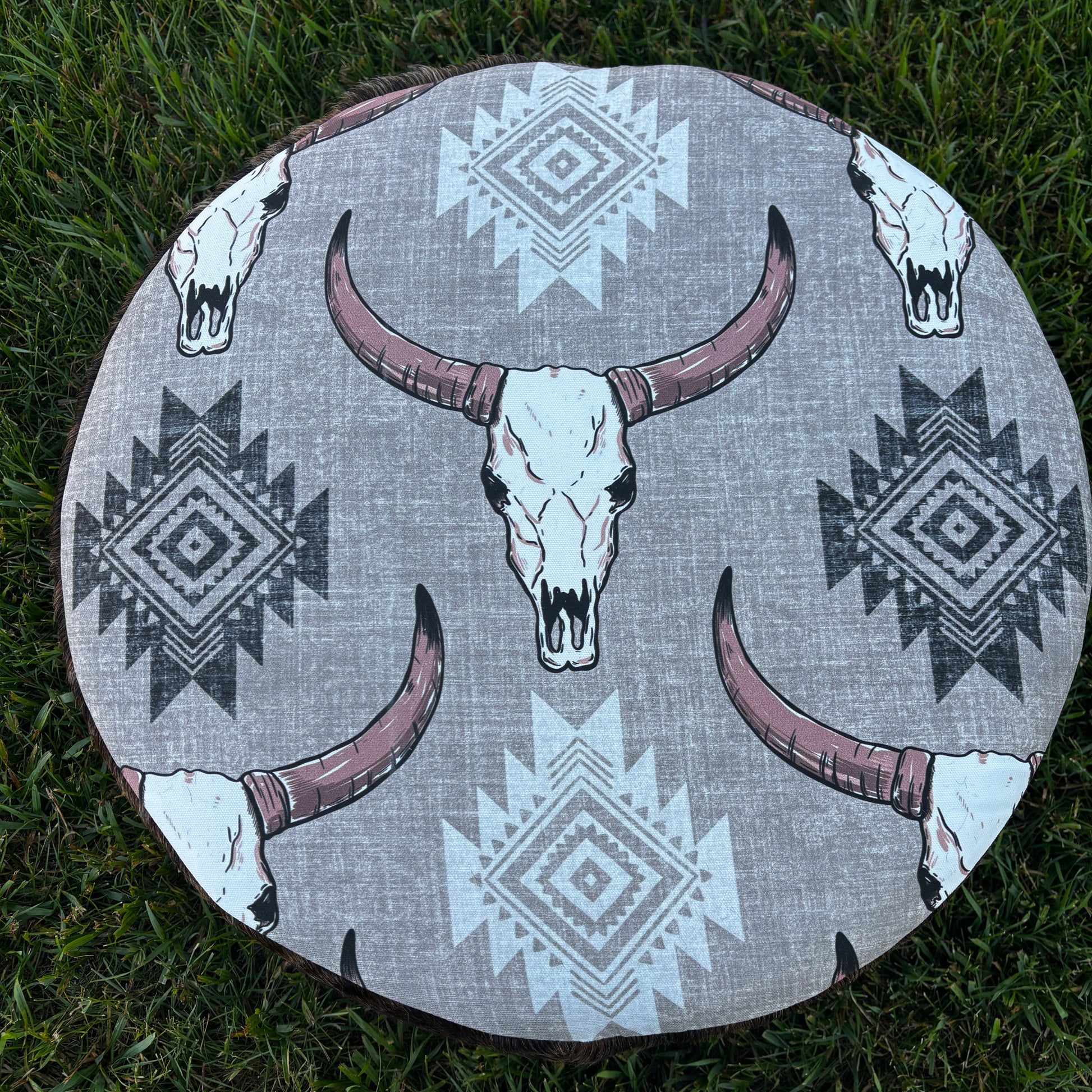 Outdoor top view of cow skull print ottoman on grass