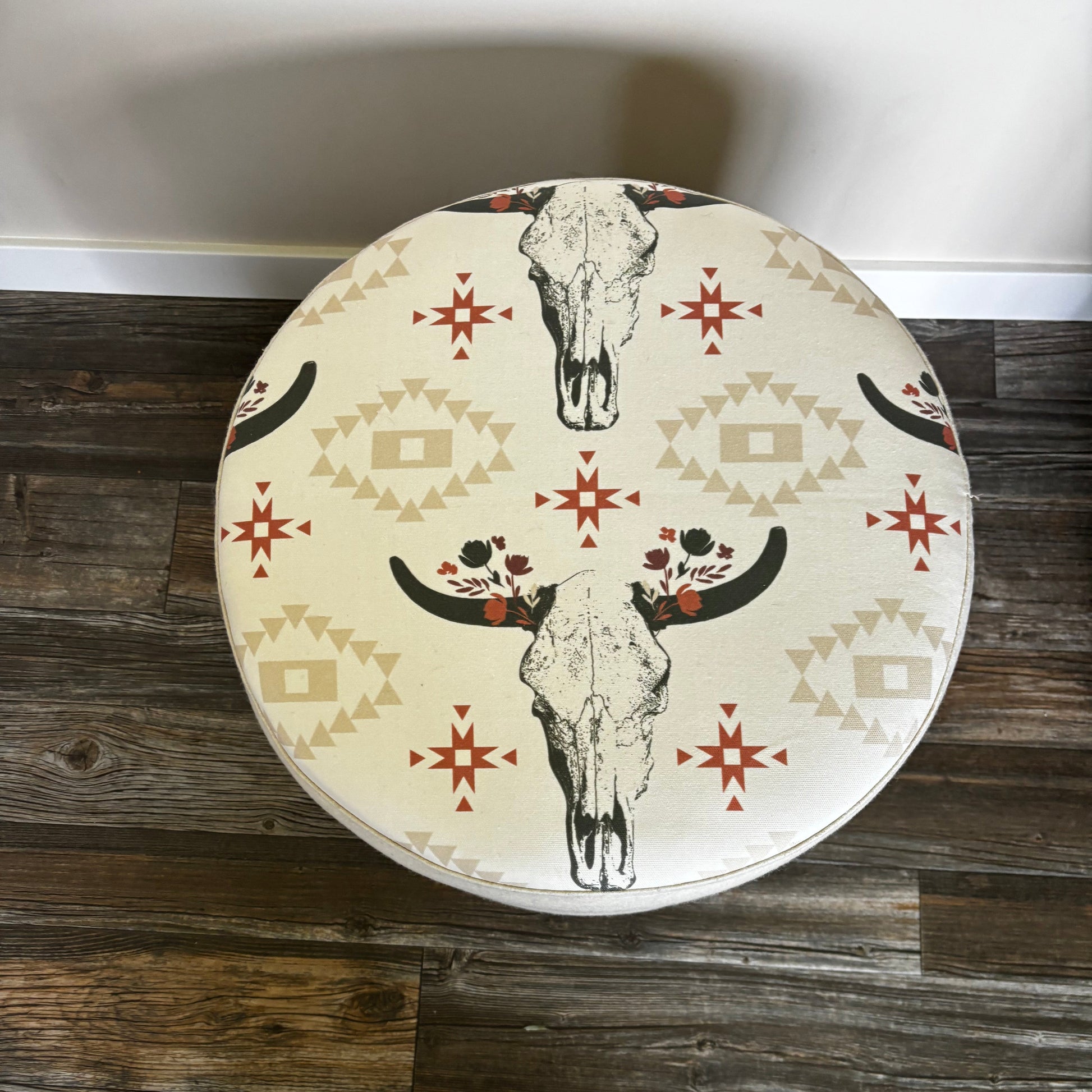 Top view of handmade ottoman featuring cow skull print on white wool fabric