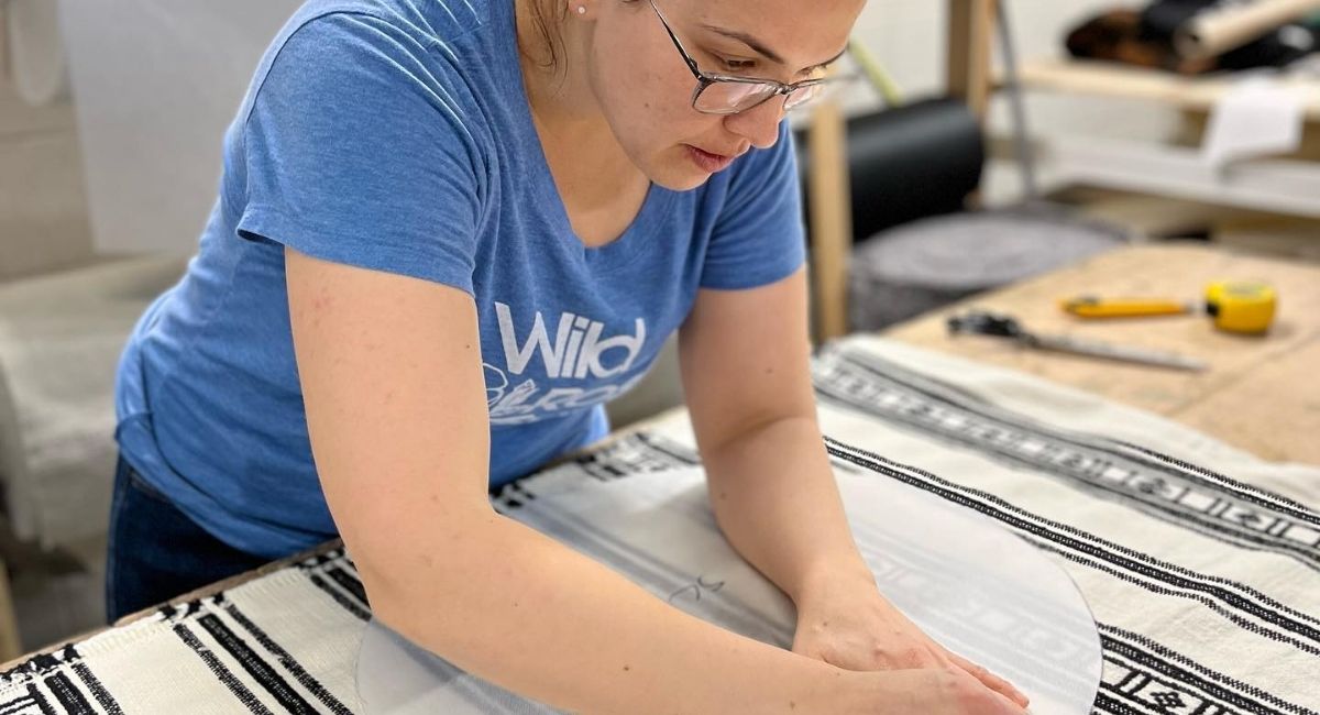 sarah working on measuring fabric in the workshop