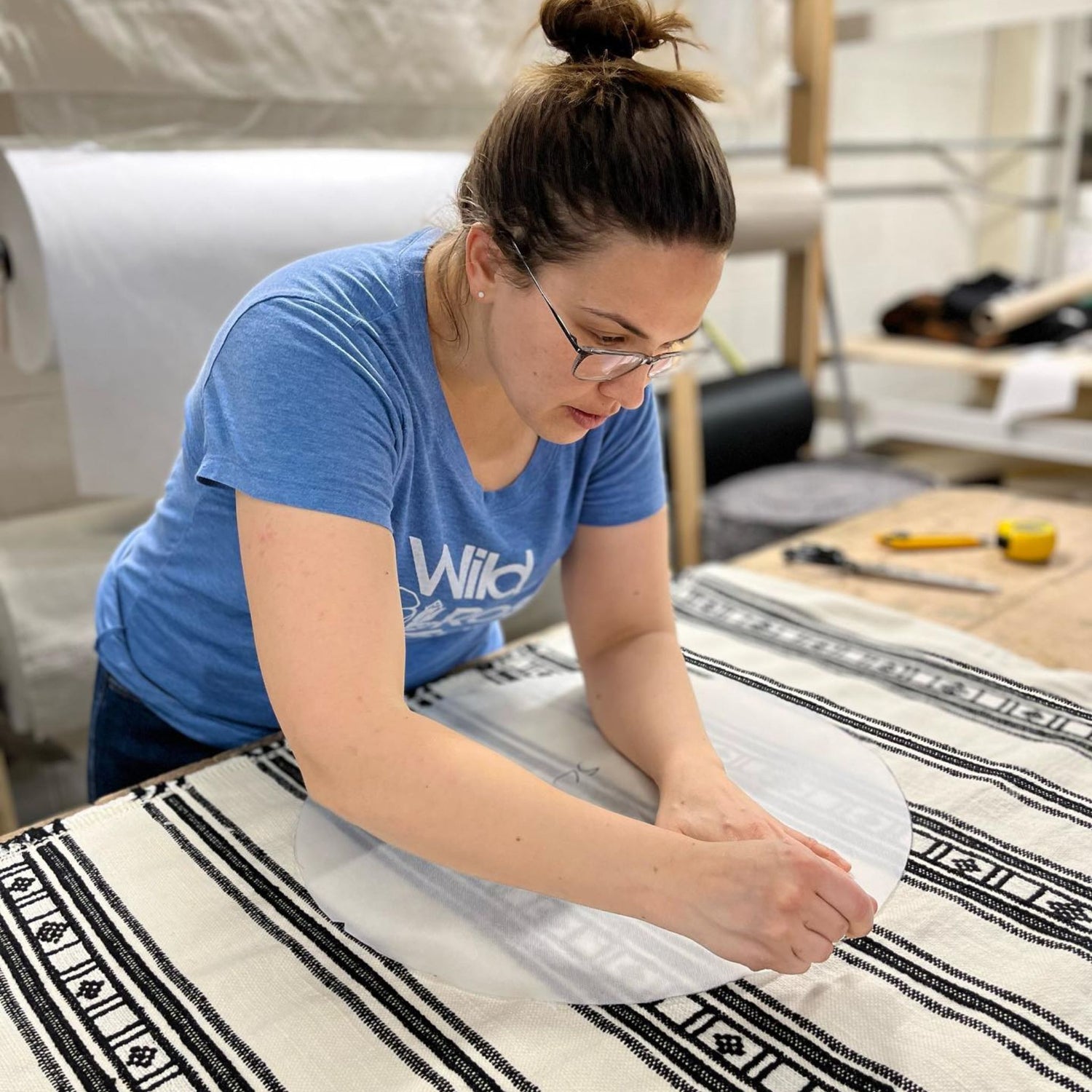 sarah working on measuring fabric in her workshop